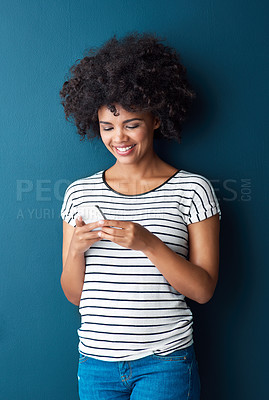 Buy stock photo African woman, phone and reading in studio with smile, thinking and typing on web for contact by blue background. Person, girl and smartphone in social media, texting and happy for meme on mobile app