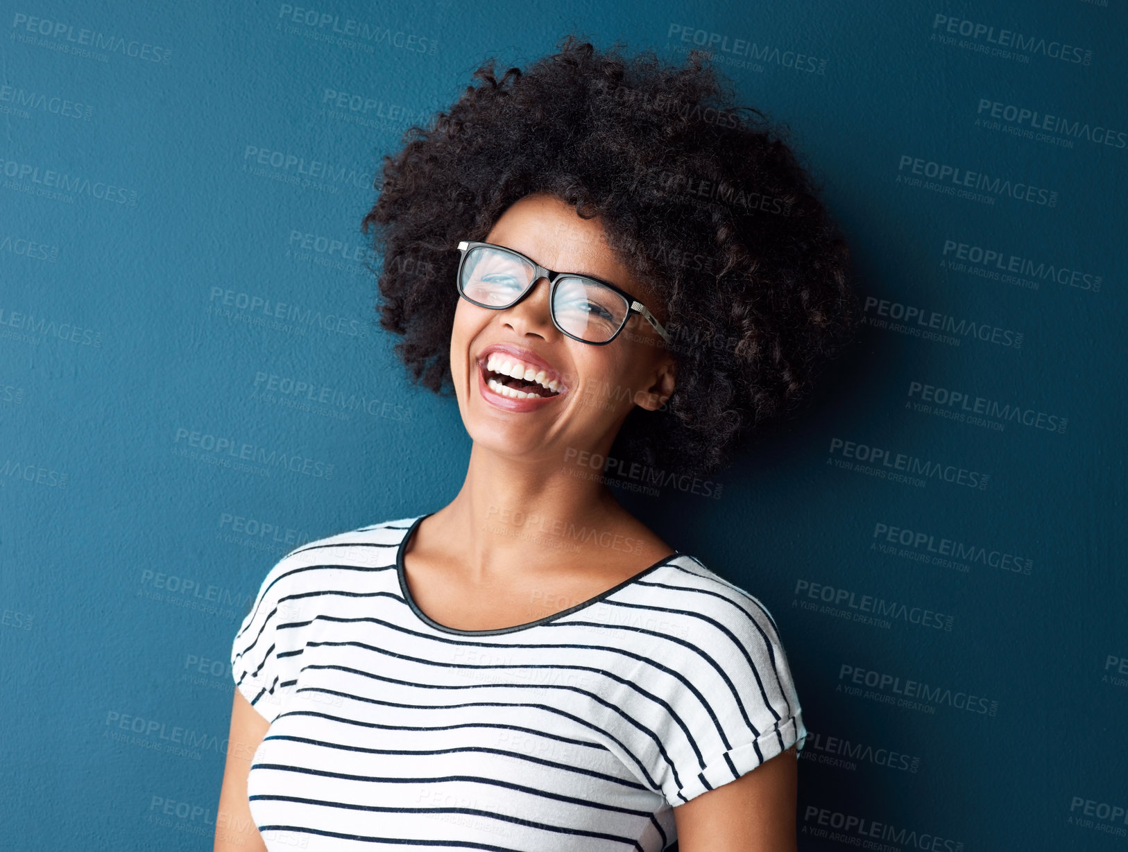 Buy stock photo Portrait, funny and woman with glasses, happiness and confident girl on blue studio background. Face, person and model with eyewear, afro and laughing for joke, humor and cheerful with joy and gen z