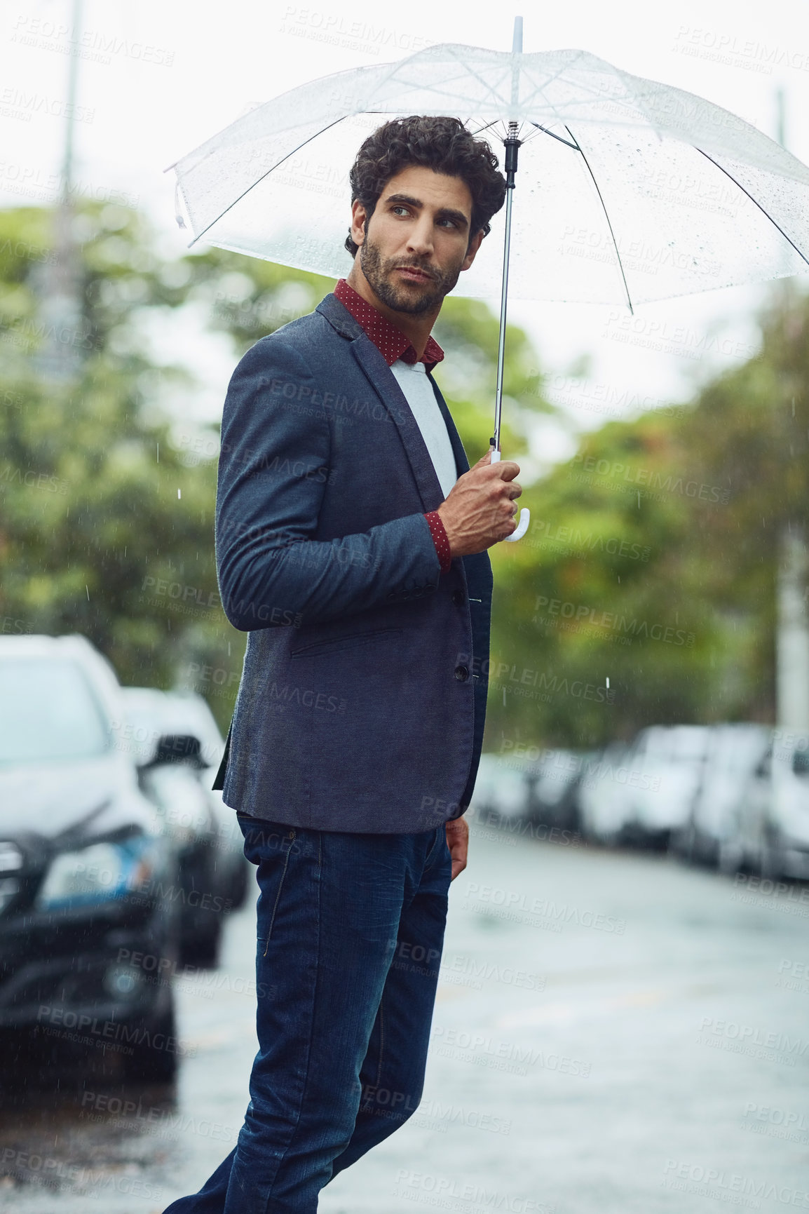 Buy stock photo Cropped shot of a handsome young businessman on his morning commute in the rain