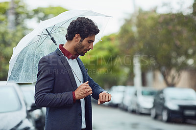 Buy stock photo Cropped shot of a handsome young businessman on his morning commute in the rain