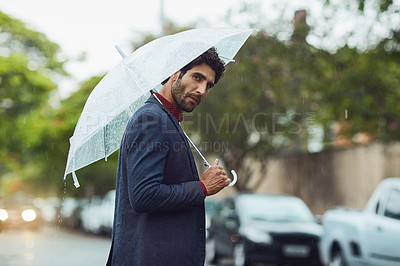 Buy stock photo Cropped shot of a handsome young businessman on his morning commute in the rain