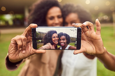 Buy stock photo Cropped shot of two female best friends taking a picture in a public park