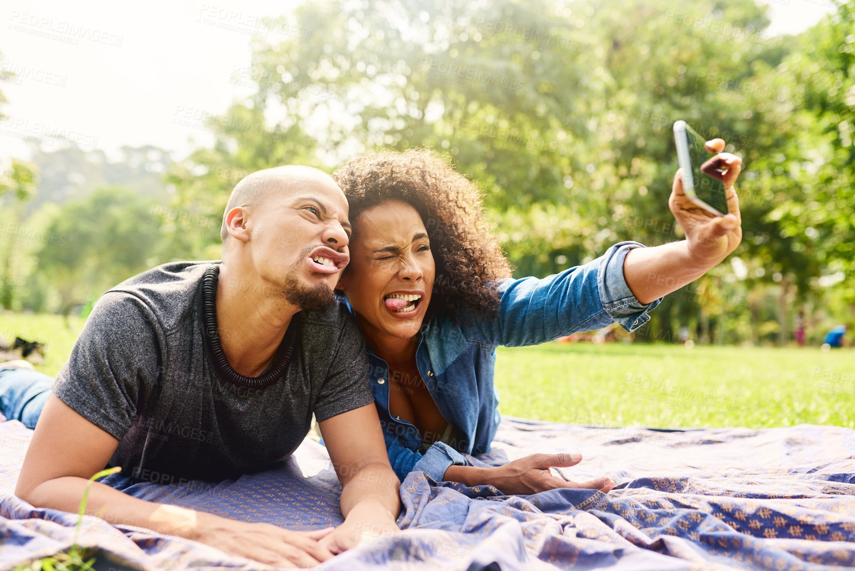 Buy stock photo Cropped shot of a young beautiful couple spending the day in a public park