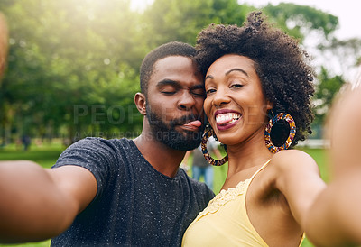 Buy stock photo Cropped portrait of an affectionate young couple taking selfies while spending some time in the park