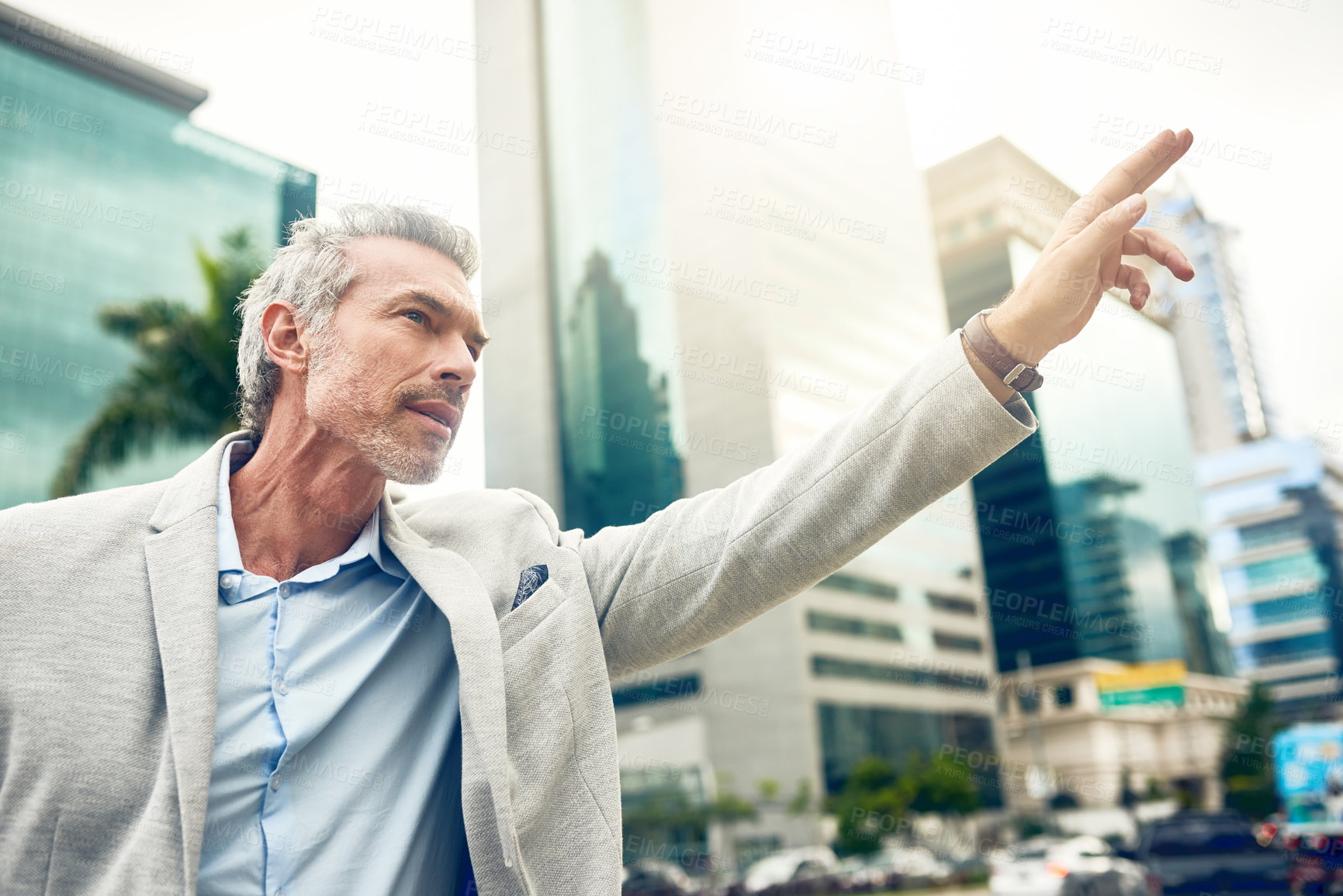 Buy stock photo Shot of a mature businessman gesturing to get a cab in the city