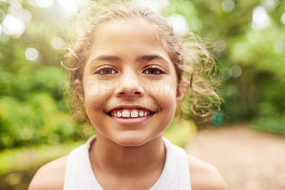 Buy stock photo Cropped portrait of an adorable little girl standing outside in the park