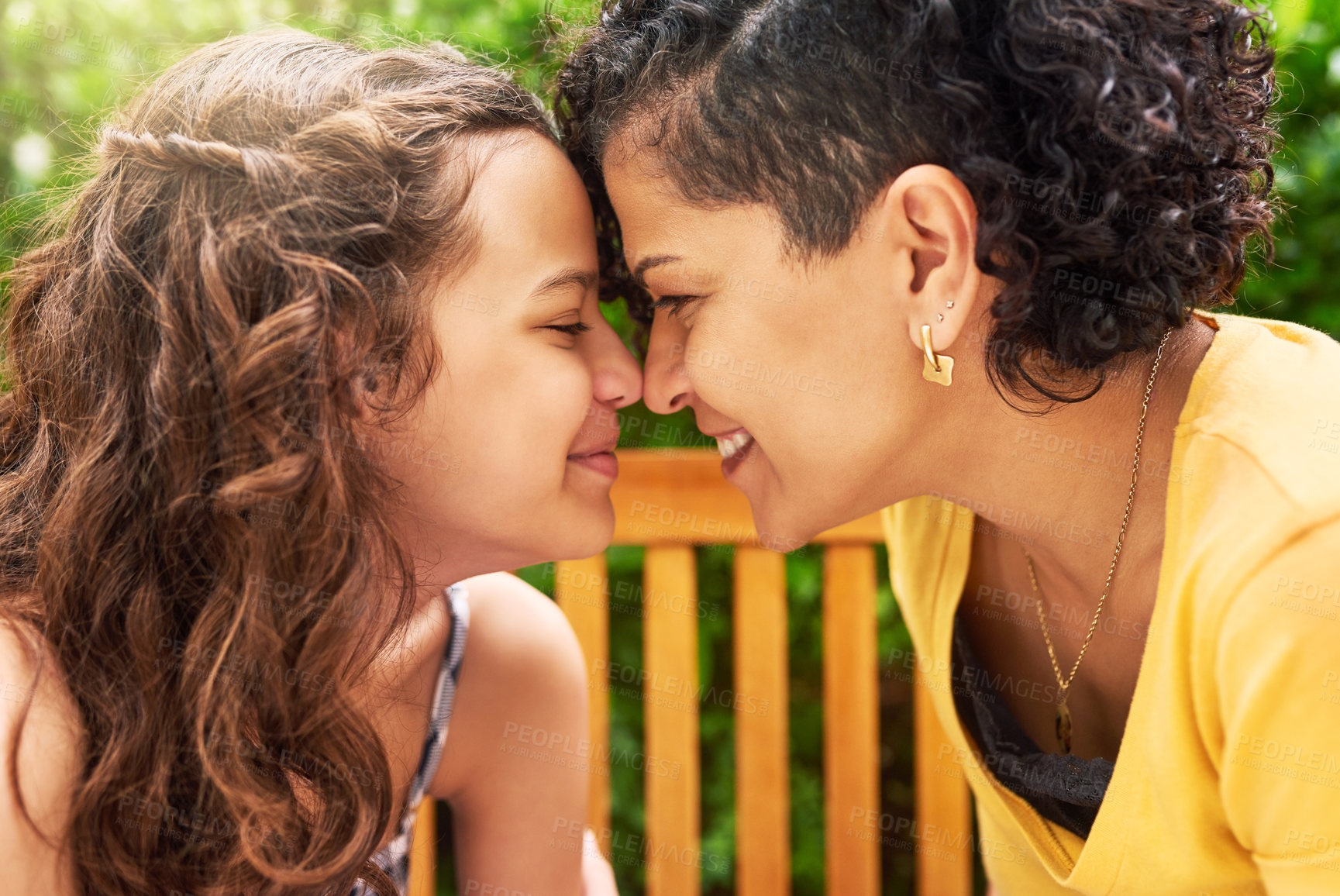 Buy stock photo Cropped shot of a young mother and her daughter sitting face to face outside in the park