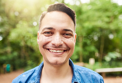 Buy stock photo Cropped portrait of a handsome young man standing outside in the park