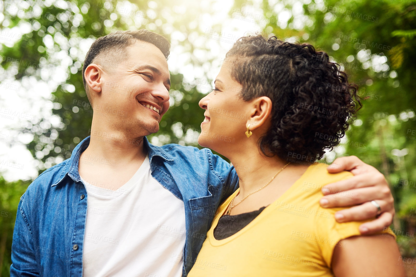 Buy stock photo Cropped shot of an affectionate young couple standing face to face outside in the park