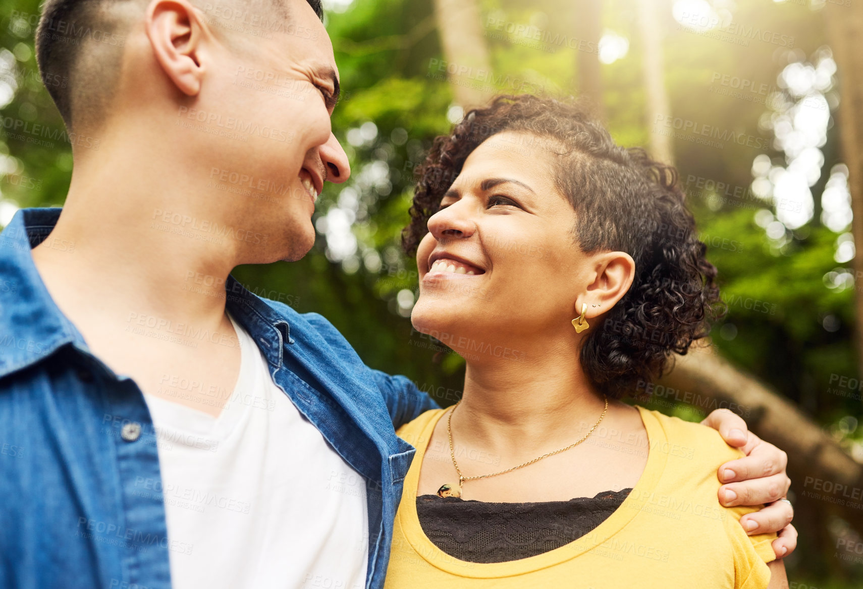 Buy stock photo Cropped shot of an affectionate young couple standing face to face outside in the park