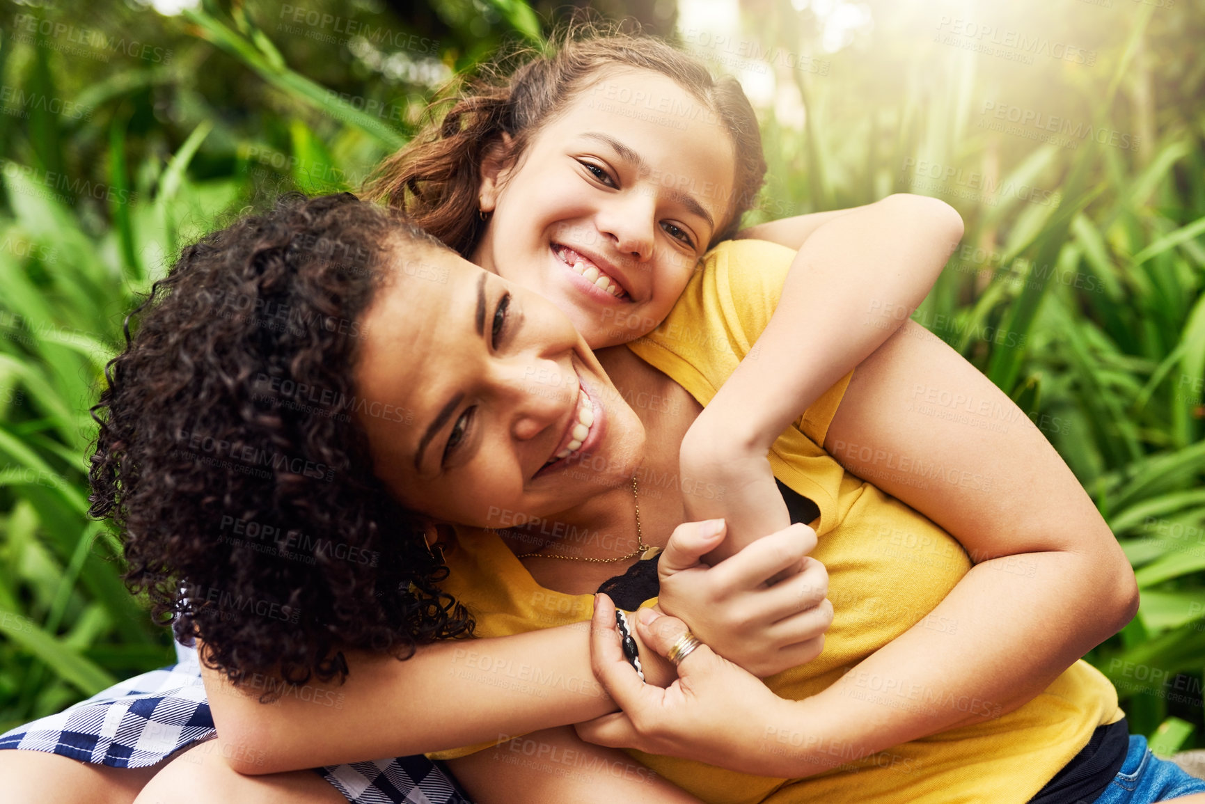Buy stock photo Cropped portrait of an adorable young girl and her mother embracing in the park