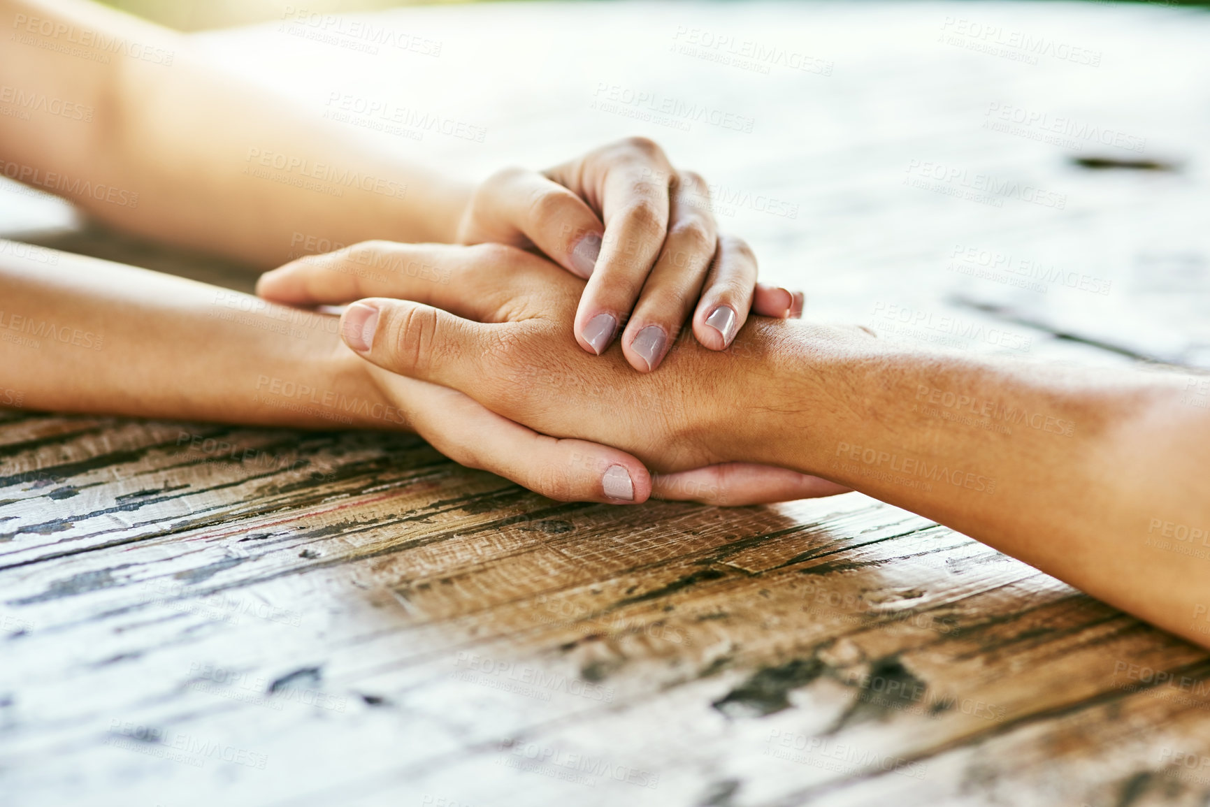 Buy stock photo Closeup shot of a man and woman holding hands in comfort on a table