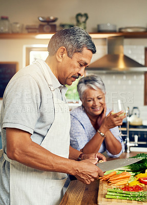 Buy stock photo Cooking, old man and happy woman with wine at kitchen counter, healthy food and marriage bonding in home. Drink, glass and vegetables, senior couple with happiness vegetable meal prep and retirement.