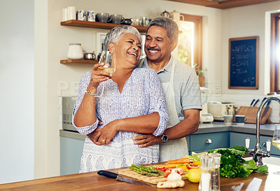 Buy stock photo Love, hug old couple in kitchen with wine, happiness and cooking healthy vegetable dinner together. Smile, embrace and food, senior man and happy woman in retirement with drink, vegetables and health