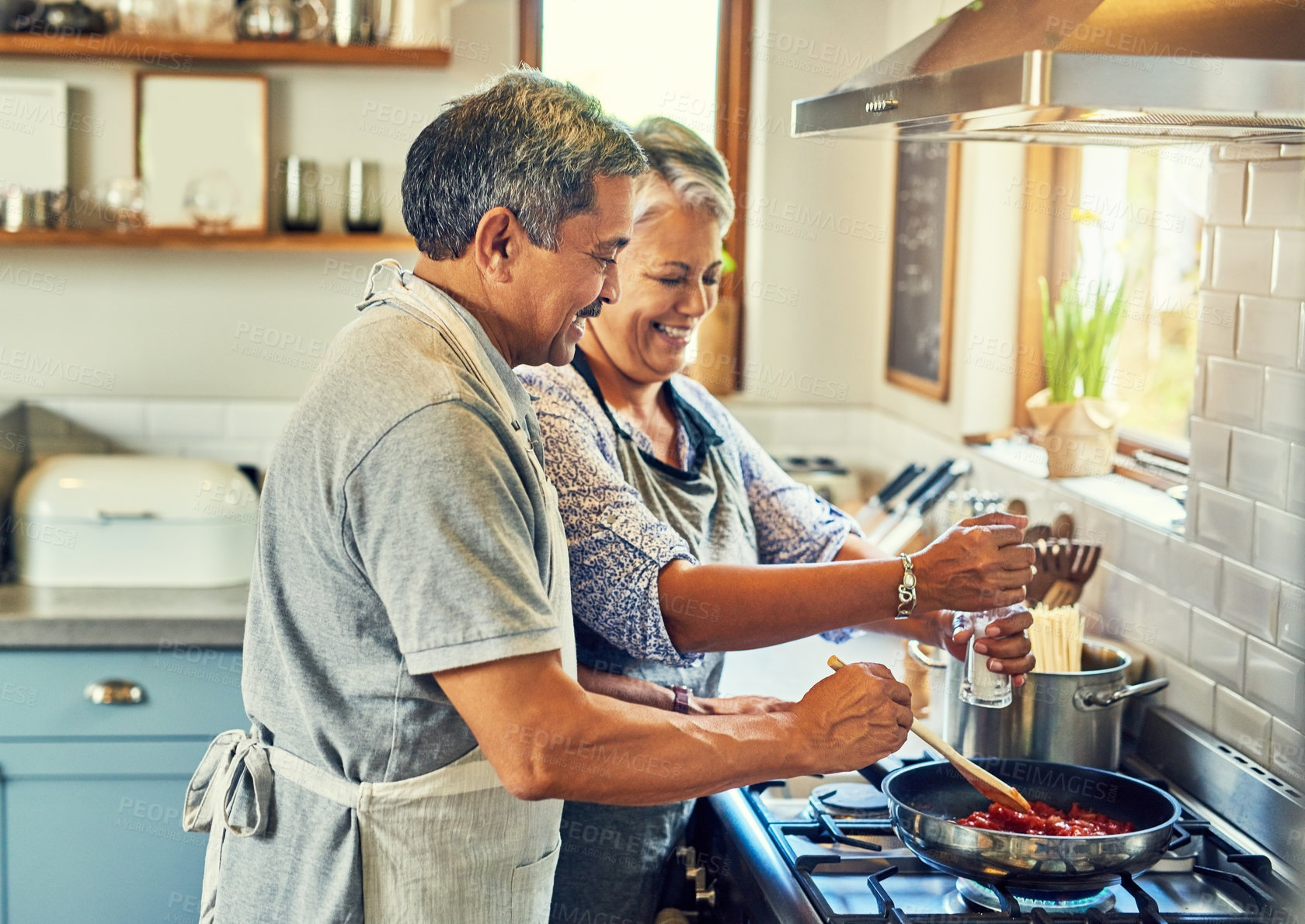 Buy stock photo Help, cooking together and old couple in kitchen with smile, health and frying healthy food at stove. Love, senior man helping happy woman prepare lunch and meal in pan, retirement and dinner in home