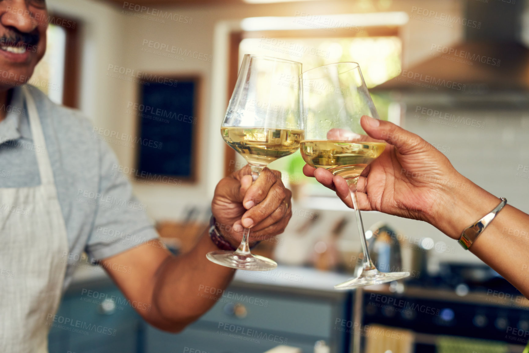 Buy stock photo Cropped shot of a mature couple toasting with wine in the kitchen at home