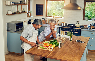 Buy stock photo Cooking, happiness and old couple with wine at kitchen counter, healthy food and marriage bonding in home. Drink, glass and vegetables, senior woman and man with vegetable meal prep and retirement.