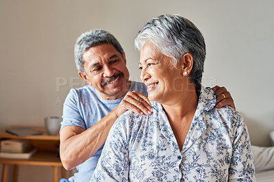 Buy stock photo Shot of a cheerful mature woman receiving a massage on her shoulders by her husband at home during the day