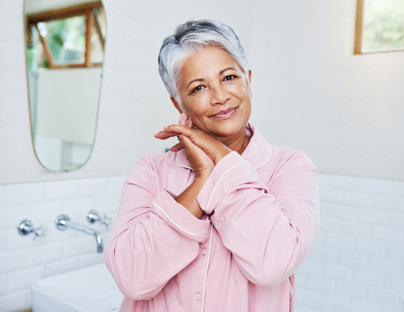 Buy stock photo Portrait of a cheerful mature woman holding her hands together while looking at the camera at home during the day