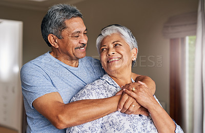 Buy stock photo Shot of a cheerful mature couple holding each other at home during the day