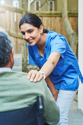 Buy stock photo Shot of a cheerful young female nurse holding the shoulder of a patient in a wheelchair for support outside at home