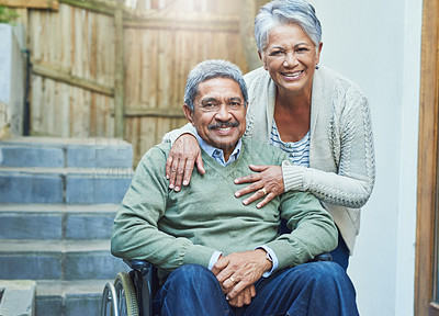 Buy stock photo Portrait of a cheerful elderly man seated in a wheelchair while being held by his loving wife outside at home during the day