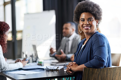 Buy stock photo Portrait of a young businesswoman sitting in an office with her colleague in the background