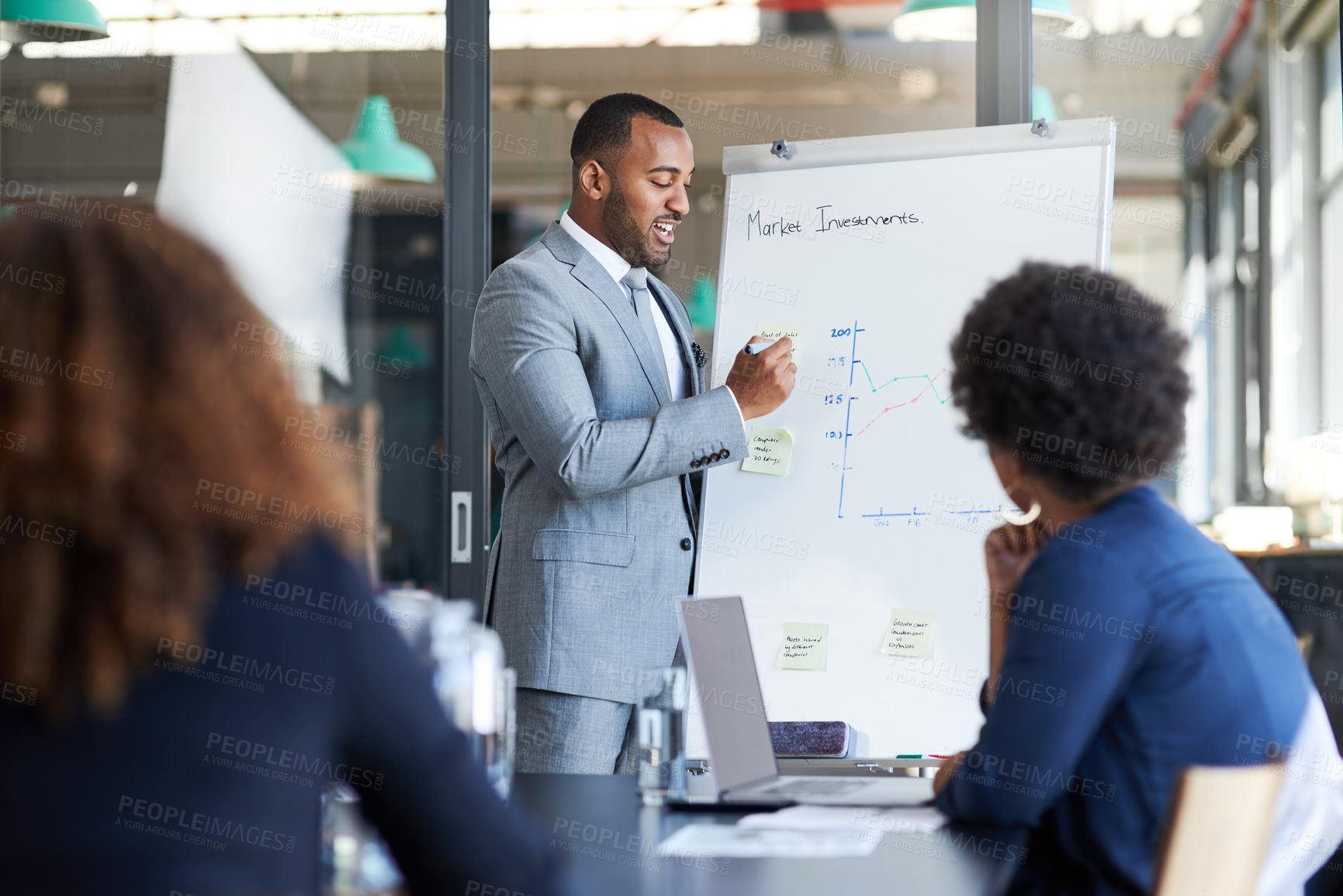 Buy stock photo Shot of a young businessman giving a presentation to his colleagues in an office
