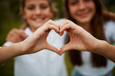 Buy stock photo Love hand sign, happy sisters in garden with fun relationship, bonding and care with siblings. Heart hands, girls and nature, kindness and friendship for teenagers in park for quality time together.