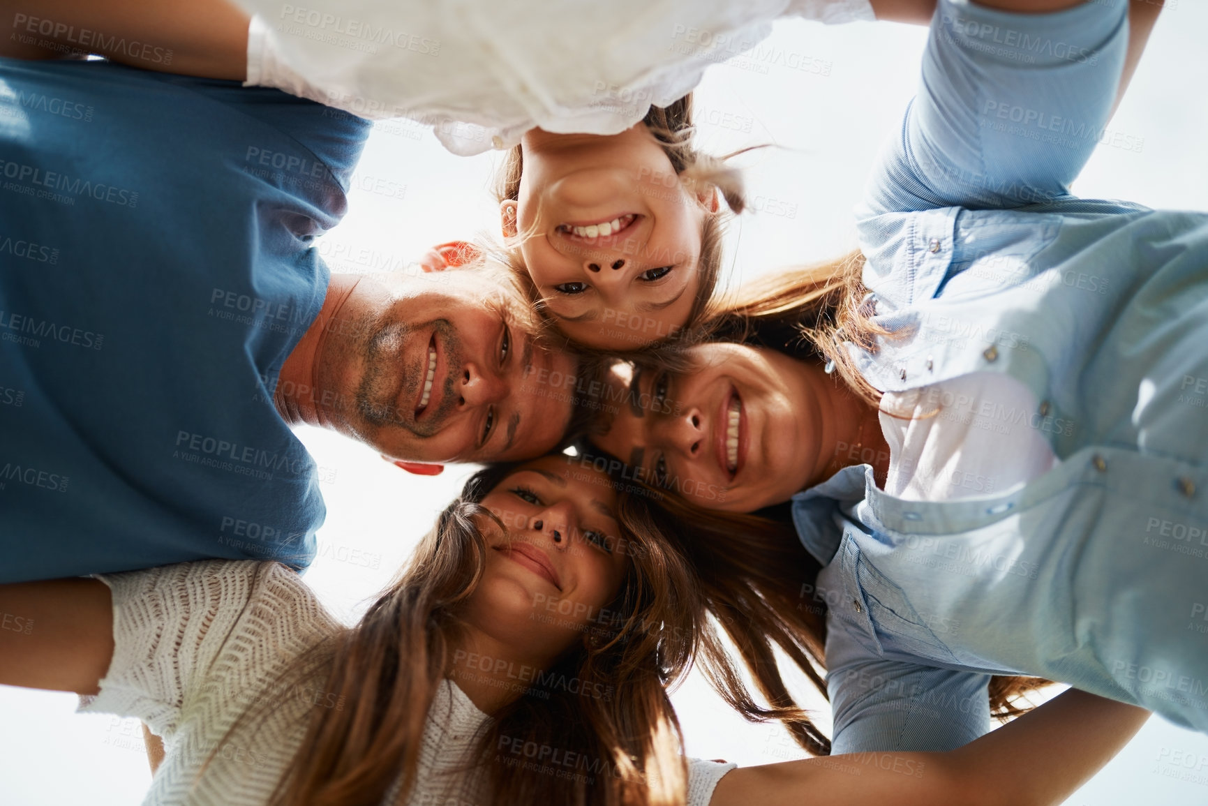 Buy stock photo Huddle, family and smile in embrace, outdoor and low angle of portrait, group and bonding in outing. Happy, people and parents with love for children, woman and man with girls, daughter and together