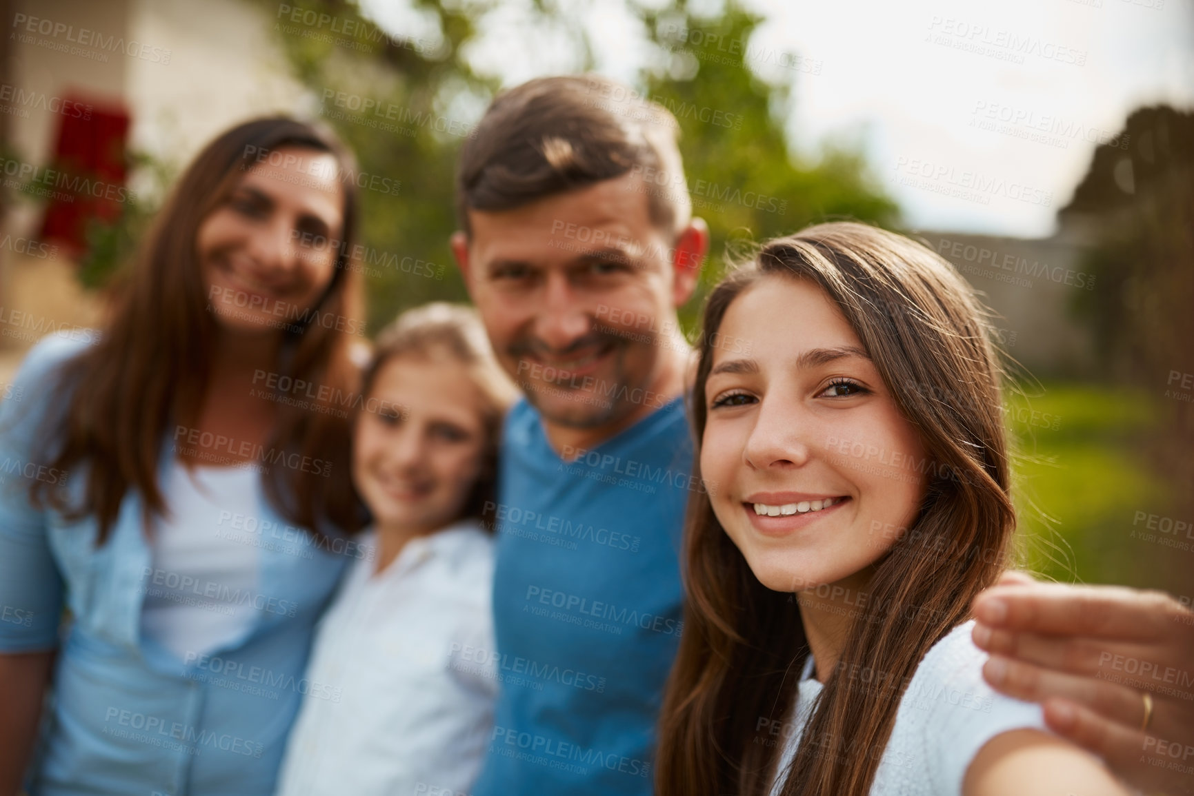 Buy stock photo Cropped portrait of a young family of four standing outside