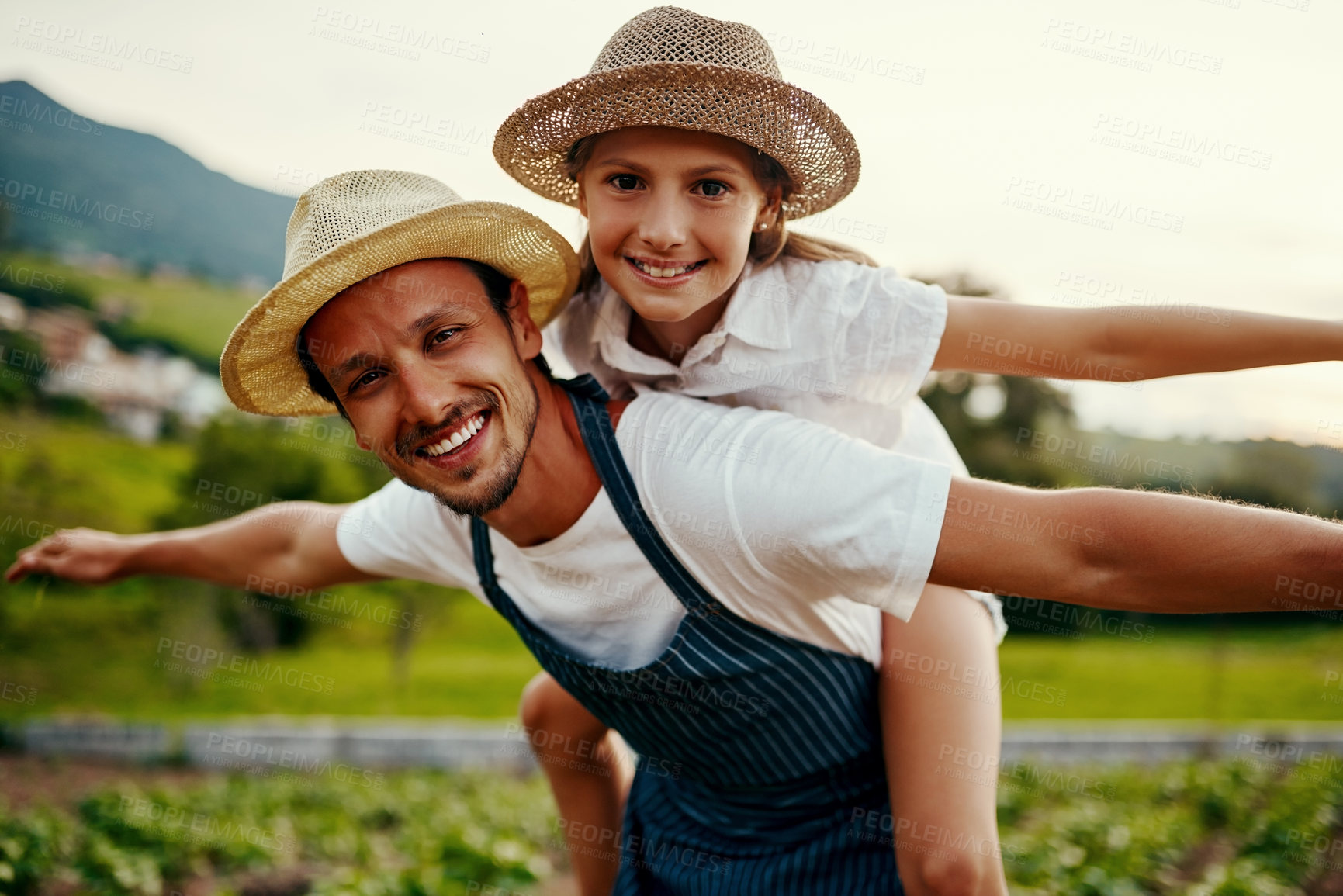 Buy stock photo Cropped portrait of a handsome man piggybacking his young daughter while working on their farm