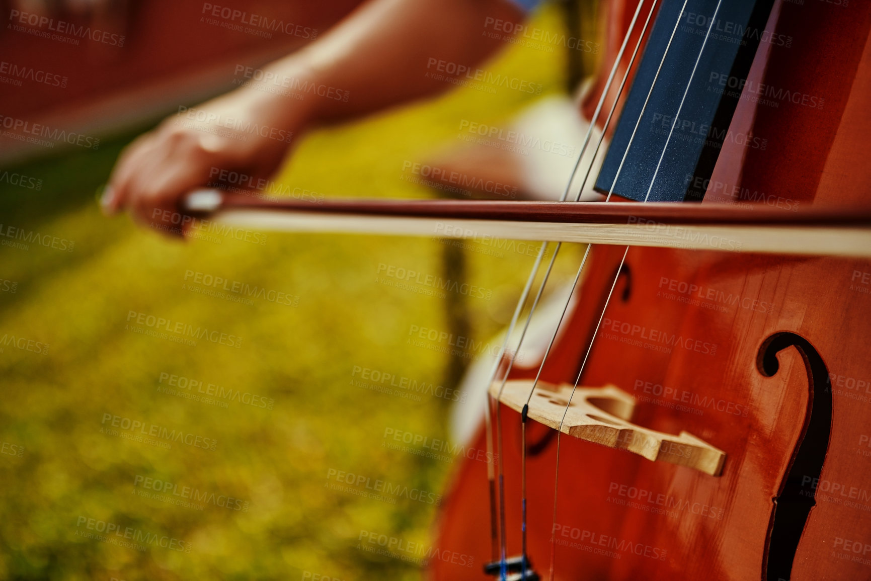 Buy stock photo Cropped shot of an unrecognizable woman playing a cello outdoors