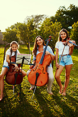 Buy stock photo Cropped shot of a beautiful mother playing instruments with her adorable daughters outdoors