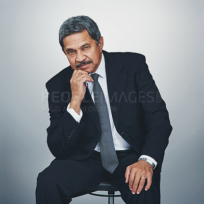 Buy stock photo Studio portrait of a mature businessman posing against a grey background