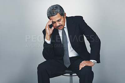 Buy stock photo Studio shot of a mature businessman looking stressed out against a grey background