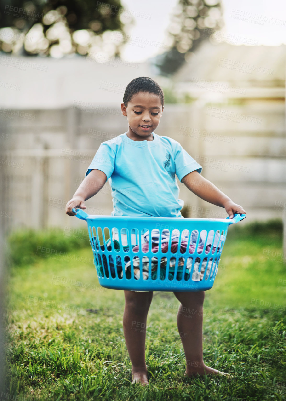 Buy stock photo Boy, kid and backyard with basket or laundry for growth, child development and learning. Outdoor, son and smile at home with washing or clothes for childhood memories, fun and house activity
