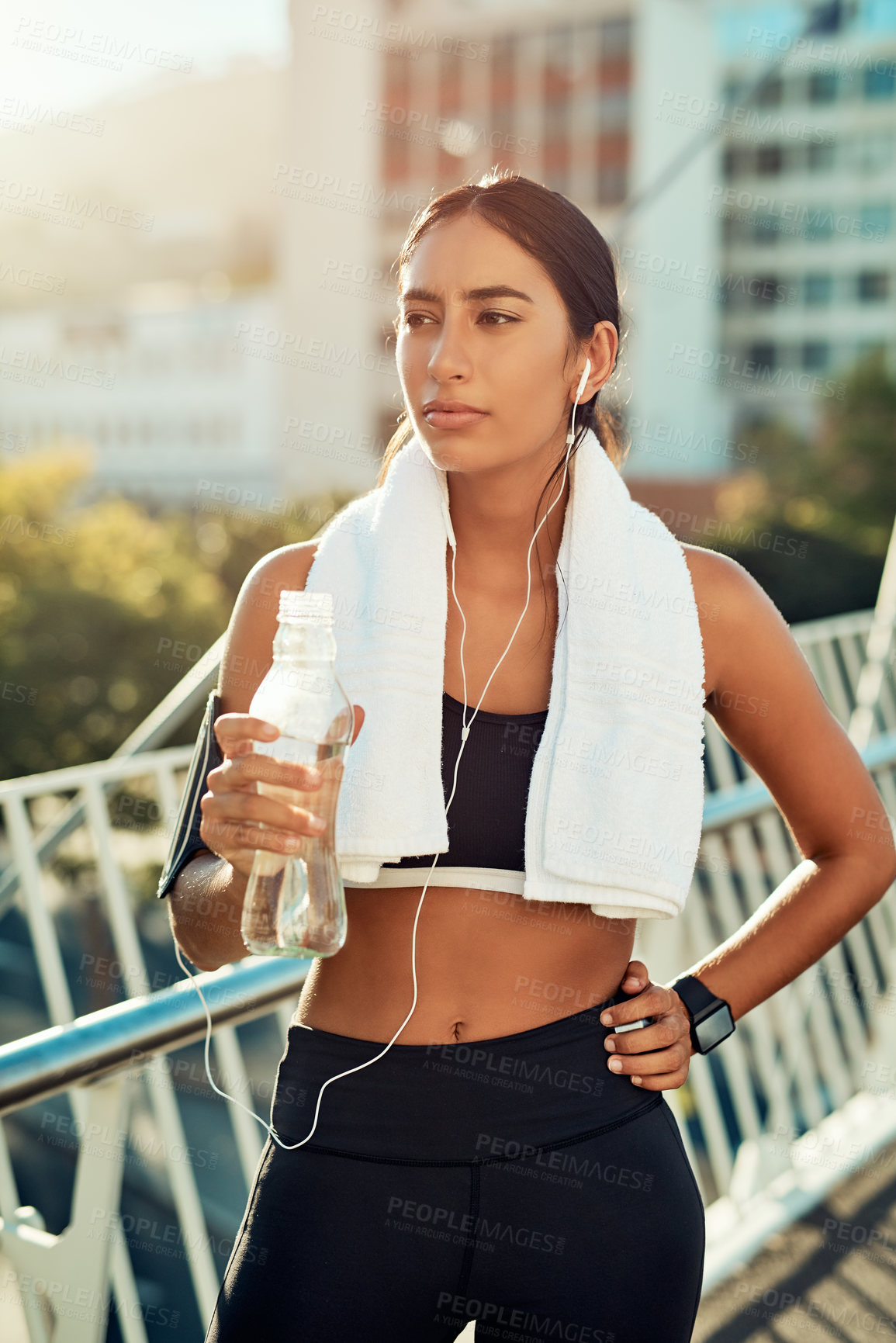 Buy stock photo Shot of a sporty young woman taking a break while exercising in the city