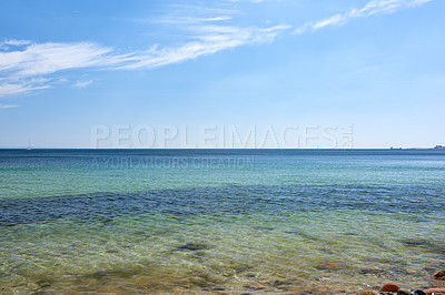 Buy stock photo Calm sea shore on a blue horizon and rocky coastline. Panoramic landscape of tropical ocean on a summer day. Tranquil view of serene beach scene, holiday destination for travel and tourism