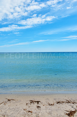 Buy stock photo Copy space at the sea with a blue sky background. Calm ocean waves at an empty beach. The scenic landscape for a relaxing summer holiday. Cloudy sky and clean water at the seashore.