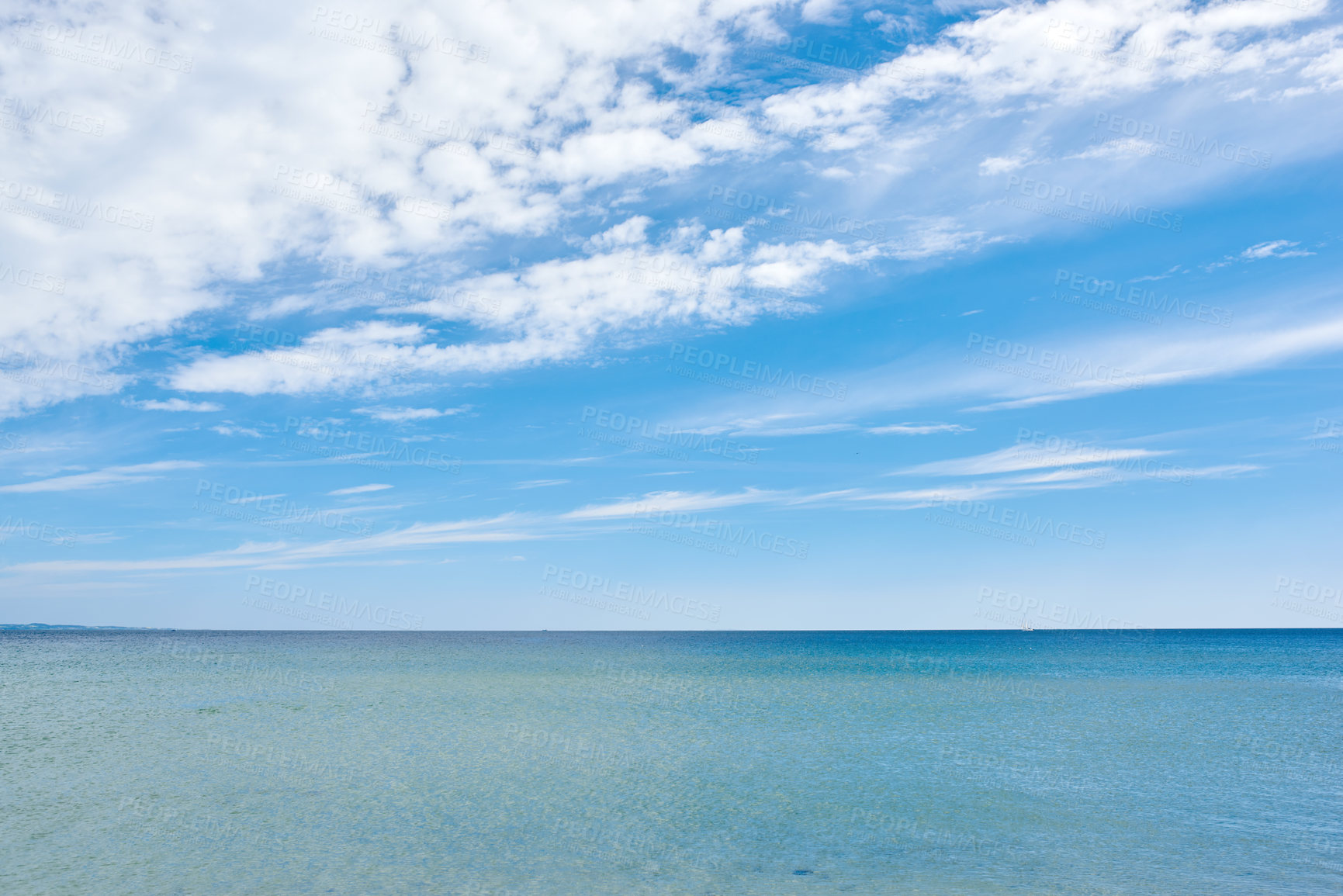 Buy stock photo Copy space at sea with a cloudy blue sky background. Calm water surface across an empty ocean across the horizon. Scenic and tranquil seascape panorama view for a peaceful summer getaway in nature