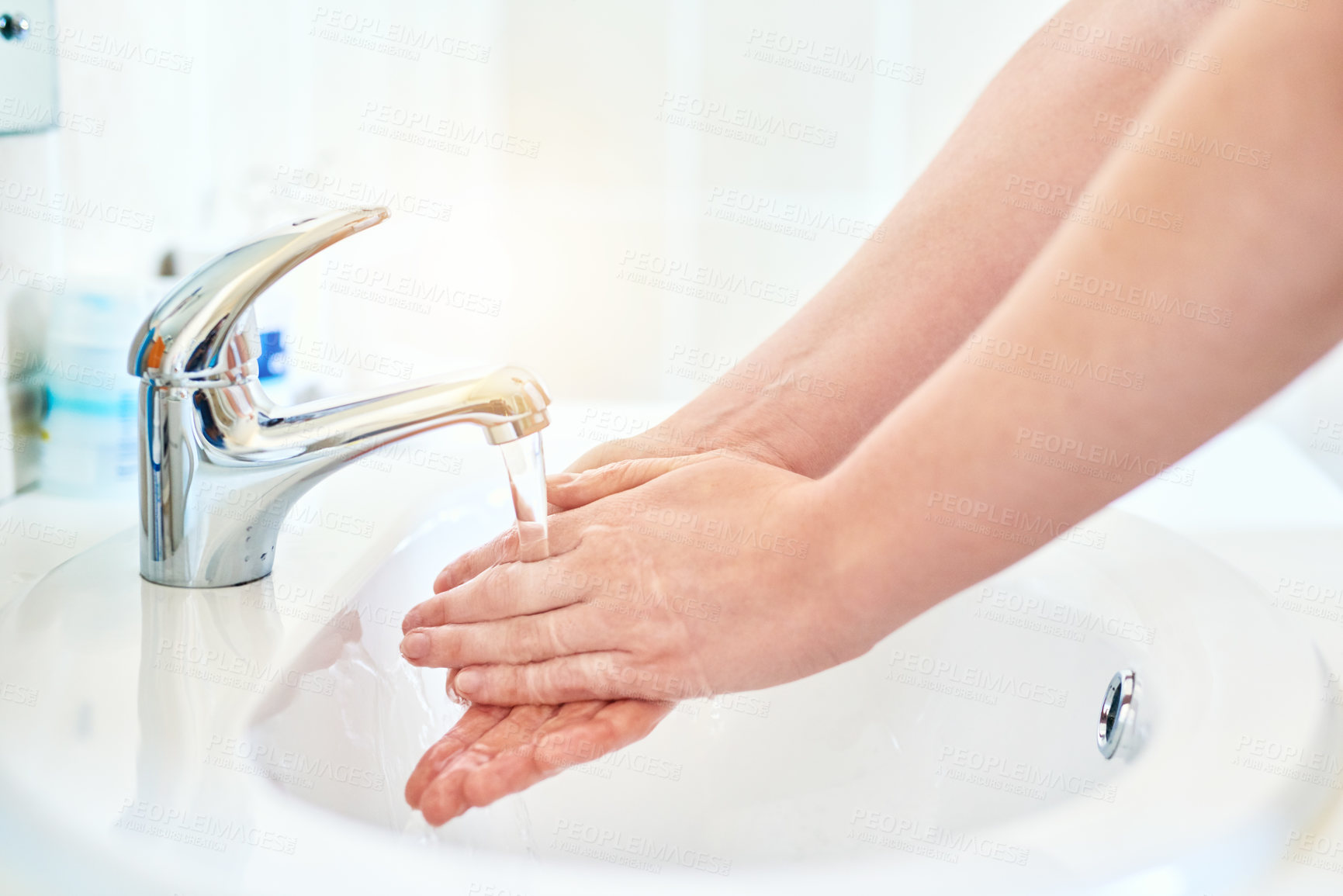Buy stock photo Closeup shot of an unrecognizable woman washing her hands in the basin in the bathroom at home