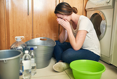 Buy stock photo Shot of a beautiful young woman crying on the floor in the kitchen at home