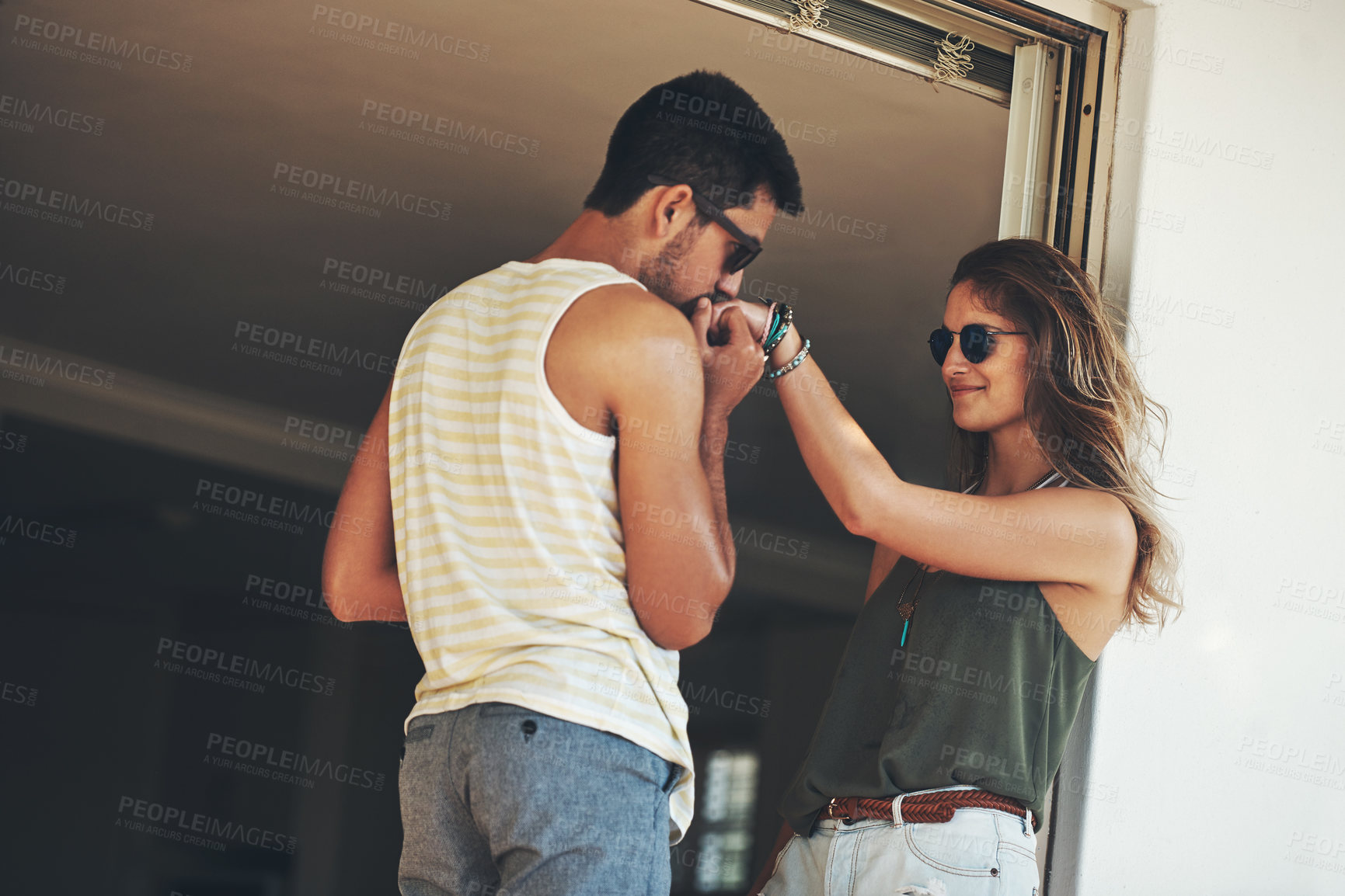 Buy stock photo Cropped shot of an affectionate young couple sharing an intimate moment outside on their balcony