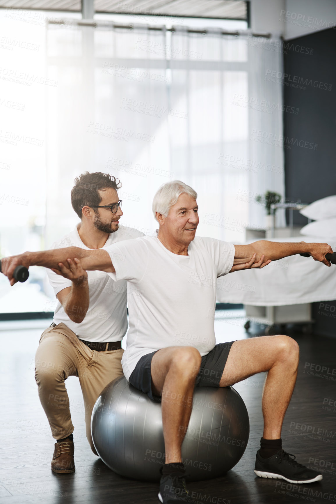 Buy stock photo Full length shot of a young male physiotherapist working with a senior male patient
