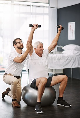 Buy stock photo Full length shot of a young male physiotherapist working with a senior male patient