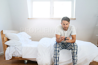 Buy stock photo Shot of a handsome young man drinking coffee in bed at home