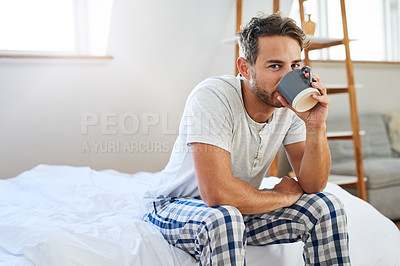 Buy stock photo Shot of a handsome young man drinking coffee in bed at home