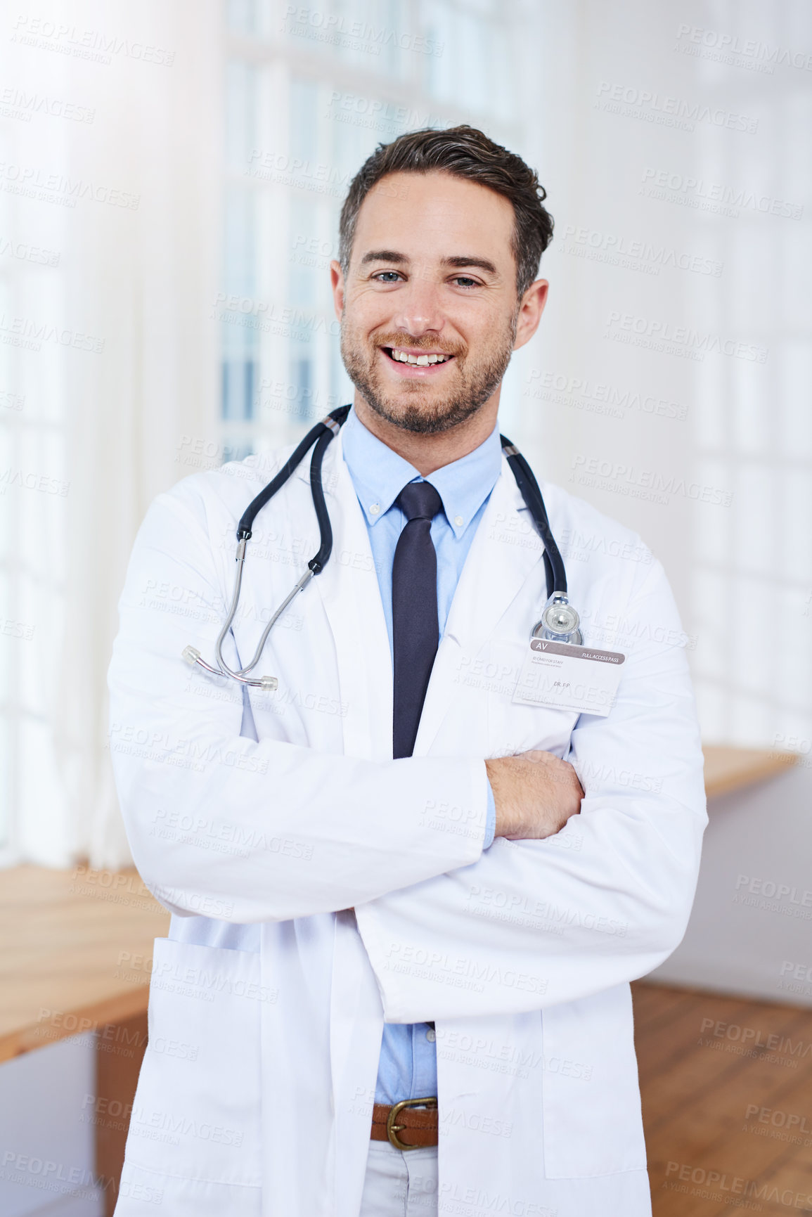 Buy stock photo Portrait of a confident young doctor standing in his consulting room
