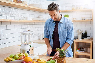 Buy stock photo House, kitchen and man cutting fruit with knife for organic smoothie, nutrition and healthy diet. Morning, appliance and male person with ingredients on table for vegan drink, detox and vitamin c